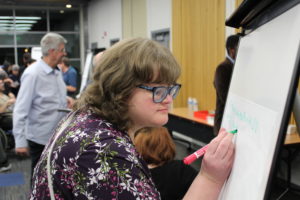 A woman writing on a poster board
